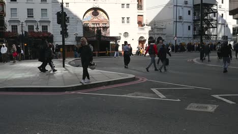 Gente-Cruzando-La-Calle-Por-El-Victoria-Palace,-Londres,-Reino-Unido