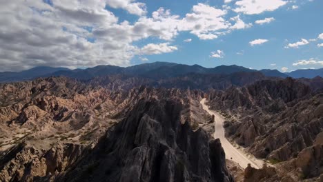 Drone-shot-flying-over-sharp-rock-formations-to-reveal-the-Quebrada-de-las-Flechas-in-Salta,-Argentina