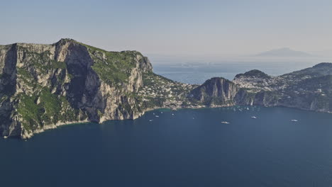 Capri-Italy-Aerial-v2-high-altitude-drone-captured-spectacular-landscape-views-of-coastal-rock-formations-and-a-rugged-cliffside-resort-town-over-the-Tyrrhenian-Sea---Shot-with-Mavic-3-Cine---May-2023