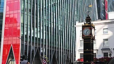 People-walking-past-the-Little-Ben-Clock,-London,-United-Kingdom