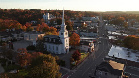 Circling-around-a-church-on-main-street-at-sunrise-in-October-in-Hudson,-Massachusetts