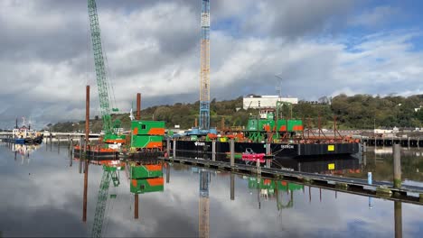 Construction-barge-moored-on-the-quays-in-Waterford-City-on-The-River-Suir-on-a-still-winter-day
