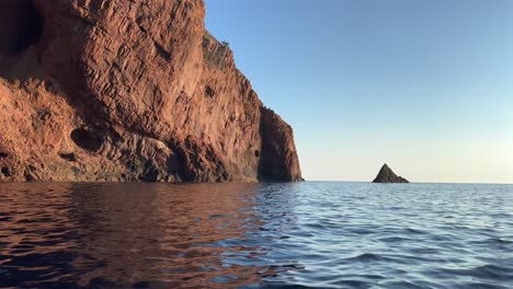 Sea-surface-point-of-view-of-rock-at-Scandola-peninsula-nature-reserve-in-summer-season-as-seen-from-moving-boat,-Corsica-island-in-France