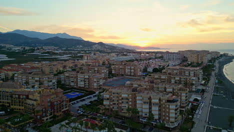Reversing-Drone-View:-Sunset-Over-Coastal-Hotels-in-Malaga