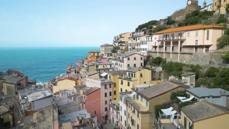 Aerial-View-Flying-through-Riomaggiore,-Cinque-Terre-towards-Ligurian-Sea