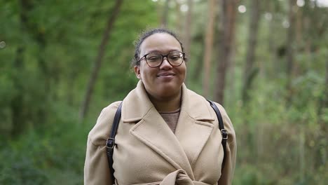 Vista-Vertical-Sonriente-De-Una-Mujer-Negra-Europea-En-El-Bosque-En-Su-Paseo-Matutino