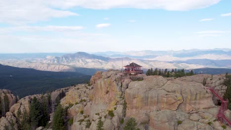 Devil's-Head-Fire-Lookout-in-Colorado-with-Pikes-Peak-in-the-background,-aerial-dronie