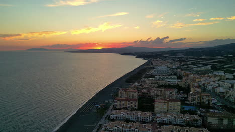 Sonnenuntergangshöhe:-Hotels-An-Der-Küste-Von-Malaga-Und-Entfernter-Gelber-Himmel,-Aufgenommen-Von-Einer-Drohne
