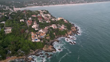 Drone-flight-over-the-beaches-of-Puerto-Escondido,-Oaxaca,-Mexico,-with-a-view-of-beachfront-houses-and-residences,-Manzanillo-Beach