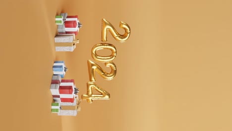 Wir-Feiern-2024-Mit-Goldenen-Luftballons-Und-Geschenken-Auf-Gelbem-Hintergrund-Vertikal