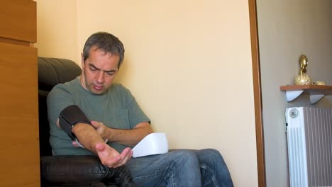 Erwachsener-Mann-Sitzt-Auf-Einem-Sofa-Und-überprüft-Zu-Hause-Seinen-Blutdruck