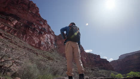 Der-Fotograf-Schaut-Sich-Um,-Während-Er-Bei-Einer-Sonnigen-Nachmittagswanderung-Seine-Kamera-Im-Grand-Canyon-Hält