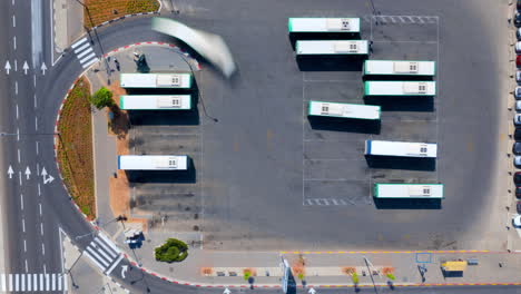 Aerial-time-lapse-of-a-central-bus-station-in-israel-After-leaving-the-complex,-the-buses-stop-at-stations-further-down-the-road---Drone-top-down-Hyperlapse