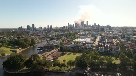 Tracking-aerial-shot-of-Perth-CBD-with-smoke-in-the-background-from-a-fire