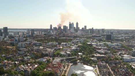 Tracking-aerial-shot-of-Perth-CBD-with-smoke-in-the-background-from-a-fire