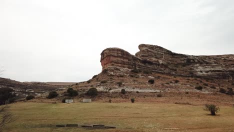Drone-shot-of-a-sandstone-formation-cliff-in-Clarens-in-the-foothills-of-the-Maluti-Mountains,-South-Africa