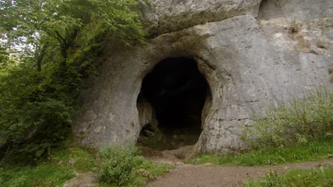 Mittlere-Aufnahme-Der-Dove-Hole-Höhle-Auf-Dem-Dove-Tale-Spaziergang-Mit-Baum-Im-Vordergrund