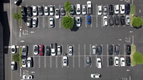 A-busy-parking-lot-in-daytime---straight-down-rising-aerial-view
