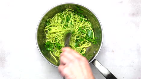 Spaghetti-And-Pesto-Being-Tossed-In-A-Pan