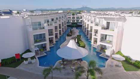 Tropical-white-hotel-resort,-modern-rooms-with-access-to-swimming-pool,-aerial