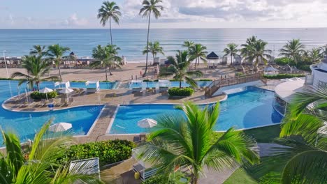 Caribbean-paradise-vacation-resort,-swimming-pool,-sand-beach-and-ocean,-drone