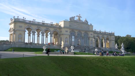 Tourists-around-Gloriette-Pavilon-on-a-sunny-day-at-Schönbrunn-Palace,-Vienna,-Austria---October-2023