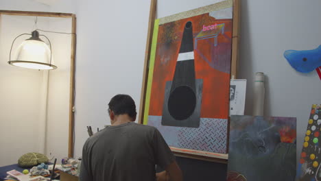 Artist-painting-a-large-oil-piece-in-his-studio