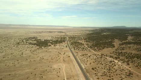 An-aerial-landscape-image-of-Route-66-highway-showcasing-a-narrow-road-and-a-horizon-in-the-distance