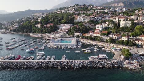 Herceg-Novi-aerial-view-with-pool,-marina,-and-lush-hillside