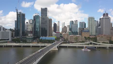 Aerial-rising-from-Brisbane-River,-CBD-in-background,-Brisbane,-Australia