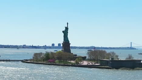 Aerial-zoom-shot-showing-famous-Statue-of-Liberty-during-sunny-day-in-New-York-City