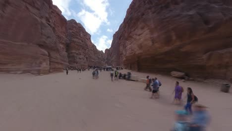Walking-through-a-slot-canyon-to-reveal-Al-Khazneh-in-Petra,-Jordan---hyper-lapse