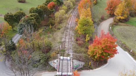 Aerial-flying-forward-over-railroad-in-countryside-during-autumn,-Caledon,-Canada