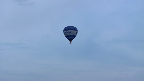 A-blue-hot-air-balloon-floating-skyward-in-a-cloudy-sky