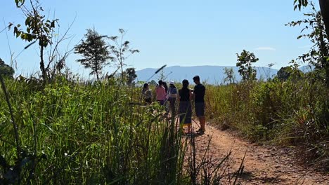 People-seen-almost-in-a-silhouette-walking-away-on-a-train-in-Khao-Yai-National-Park-revealing-a-lovely-sunny-day-and-a-picturesque-landscape,-Thailand
