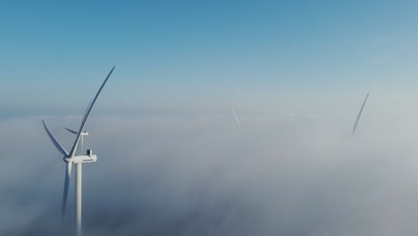 Neblige-Wolken-Umhüllen-Windkraftanlagen-über-Dem-Sonnenaufgangshimmel