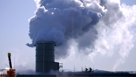 Geothermal-plants-burning-fossil-fuels-to-produce-electricity,-Cimney-discharging-dense-smoke,-contaminated-gas-in-the-atmosphere,-Global-warming