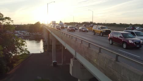 Rising-Drone-Shot-over-Interstate-at-Rush-Hour,-Heavy-Traffic-on-Bridge,-at-Golden-Hour