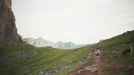 Female-Wanderlust-Hiking-With-Pet-Dog-On-Hesten-Trail-Near-Segla-Mountain-In-Norway