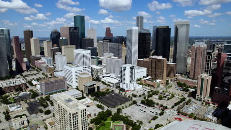 Aerial-pull-back-in-front-of-the-skyline-of-downtown-Houston,-sunny-Texas,-USA