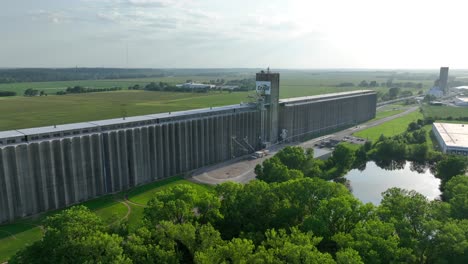 Cargill-grain-elevator-in-Topeka,-Kansas,-with-vast-green-fields-in-the-background