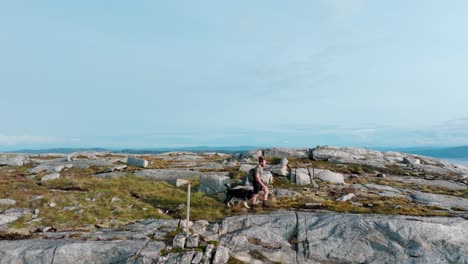 Mann,-Begleitet-Von-Einem-Hund,-Navigiert-Durch-Das-Gelände-In-Der-Nähe-Von-Rissa-Und-Hasselvika-Im-Berg-Bla-Heia-In-Norwegen-–-Handheld