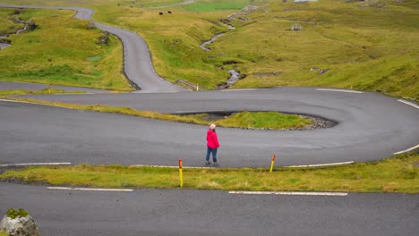 Woman-in-Nordradalsskard-mountain-pass,-Faroe-Islands,-raising-arms-and-admiring-Faroese-landscape