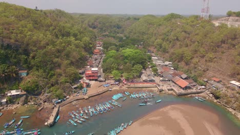 Birds-eye-view-of-Indonesian-scenic-Baron-Beach-Fishing-Village-at-day,-dolly-out