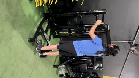 Latin-man-with-long-hair-and-beard-doing-standing-calf-exercises-on-gym-equipment