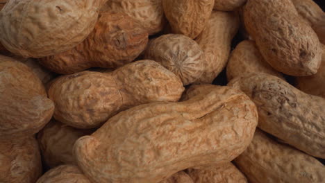 Peanuts-in-shells-macro-moving,-food-product-used-in-recipes-like-chocolates,-sauces-and-oils,-known-allergen,-healthy-nuts,-peanut-allergy,-4K-top-shot