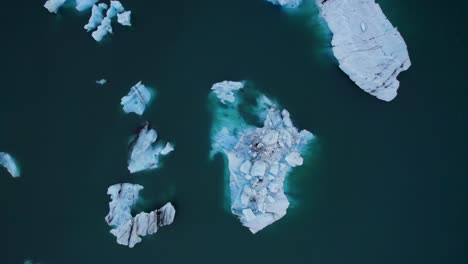 Luftaufstieg-Von-Eisberg-Eisblöcken,-Die-Auf-Dem-Blauen-See-Der-Polarregion-Schwimmen
