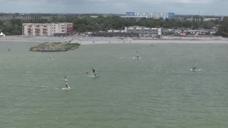Makkum-beach-with-windsurfers-during-a-stormy-day,-aerial