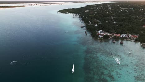 Aerial-of-seven-colours-lake-lagoon-in-Bacalar-Mexico-drone-fly-above-scenic-natural-seascape-and-sailboat-resort-beach-town