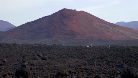 Stetige-Aufnahme-Eines-Vulkanbergs-Im-Hintergrund,-Der-Während-Des-Letzten-Lavaausbruchs-Aus-Einem-Vulkankrater-Auf-Lanzarote-Entstanden-Ist